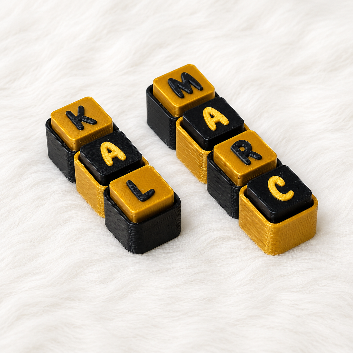 Black and gold personalized name keychains spelling KALM and MARC