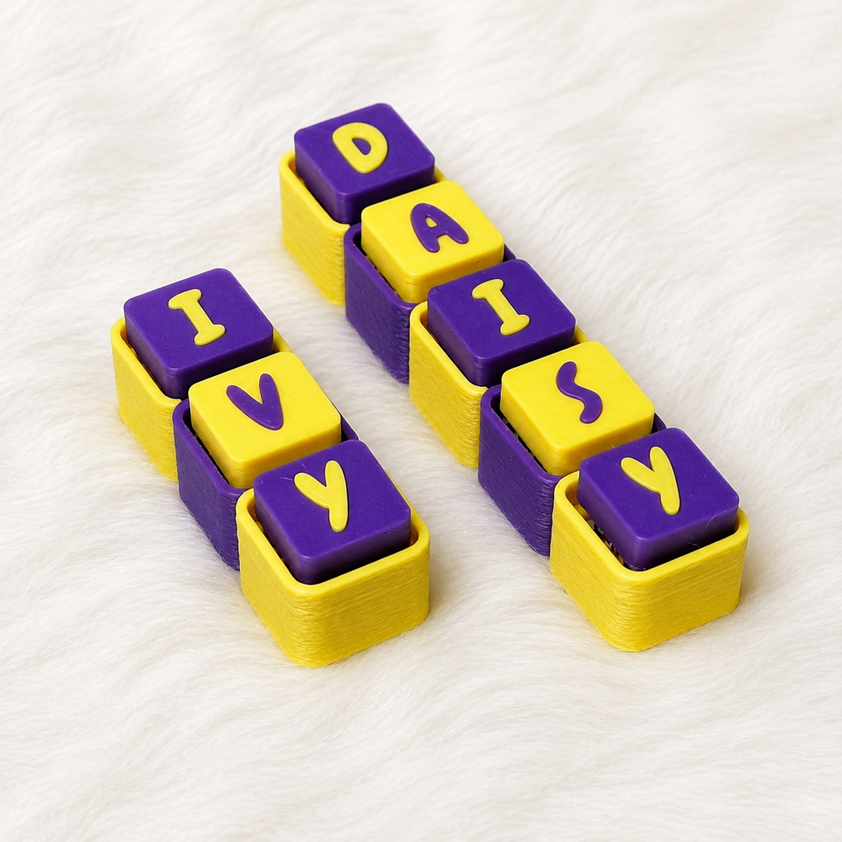 Purple and yellow personalized name keychain spelling DAISY on a white background